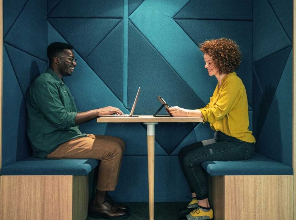 Two people working together in a booth