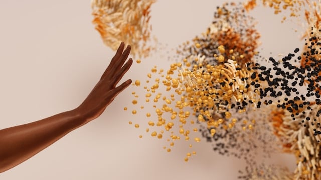 A hand extended to various coloured particles