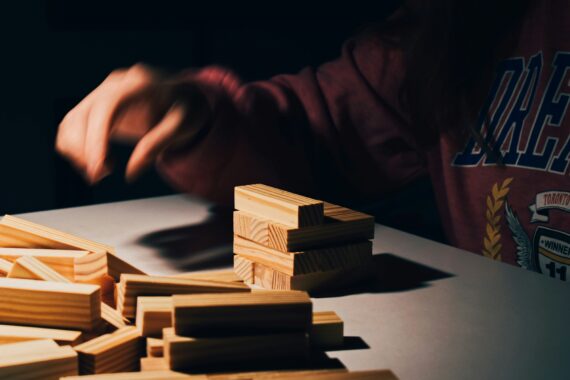 An image of a person building up blocks of wood into a stable tower