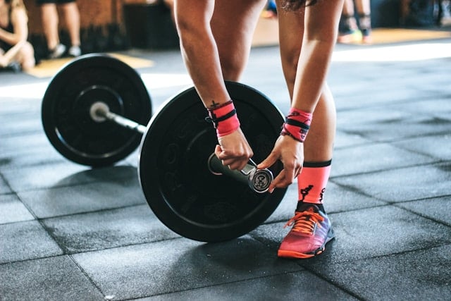 An image of a hand ready to work with a large dumbbell