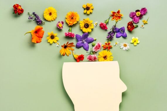 a paper cut out of a head with flowers coming out of the top