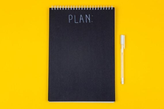 a yellow table with a black planner