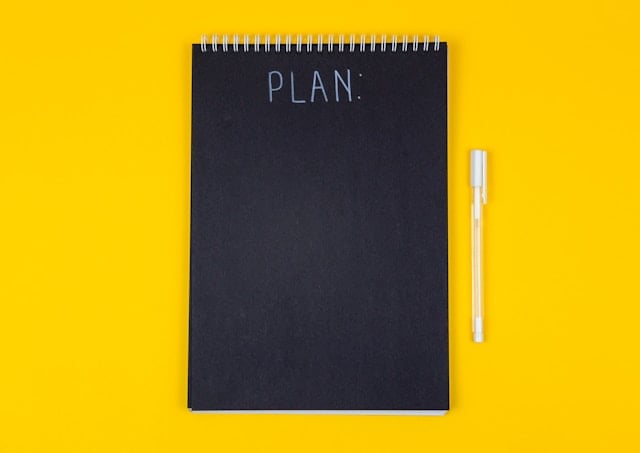 a yellow table with a black planner